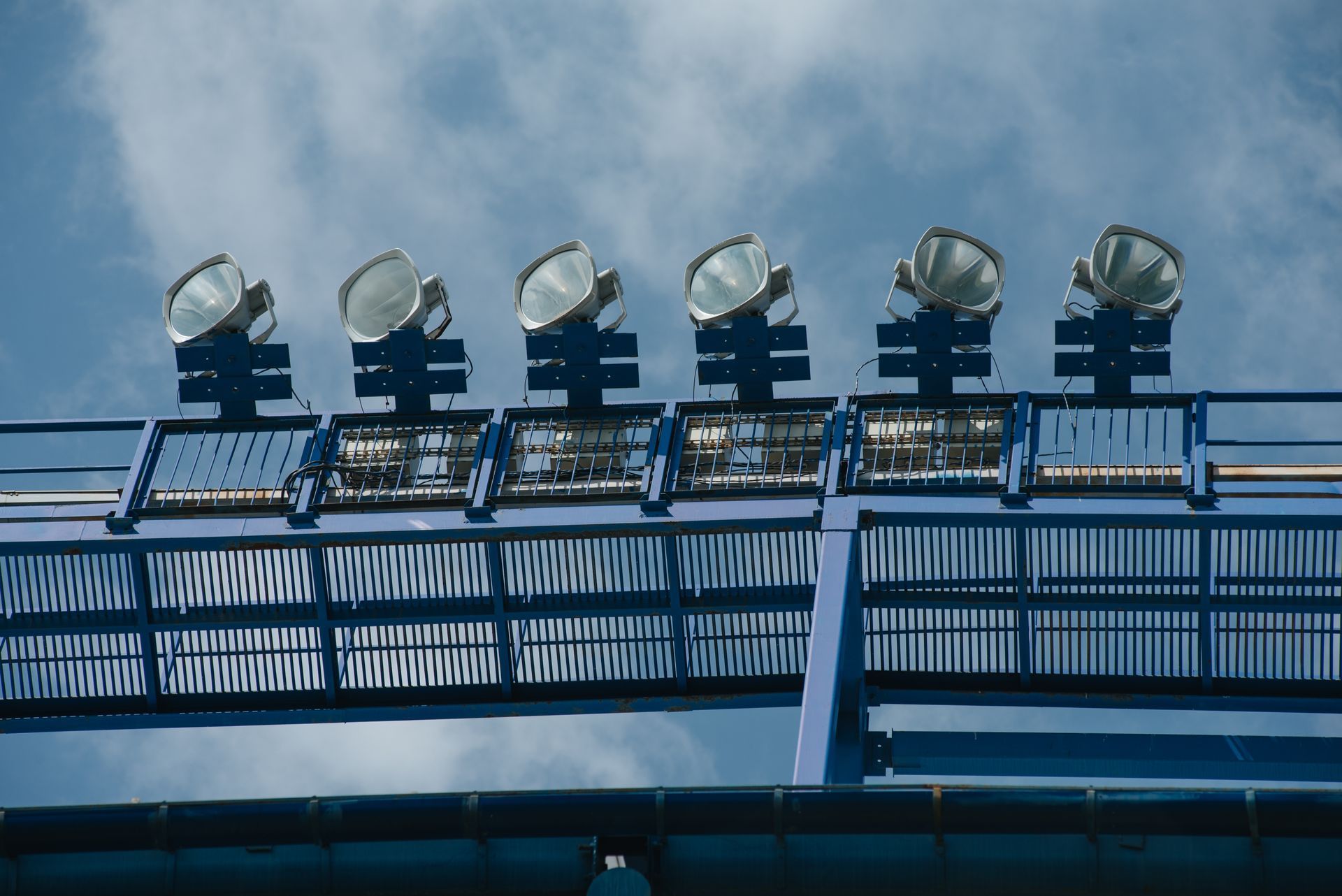 Floodlight mast with some lights on against a dark blue sky, close-up. Floodlight mast with some lights on against a dark blue sky, close-up.