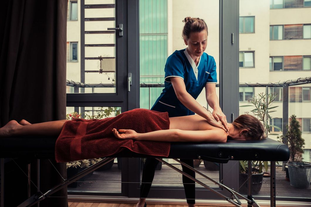 Massage therapist working on a patient's shoulder and neck 