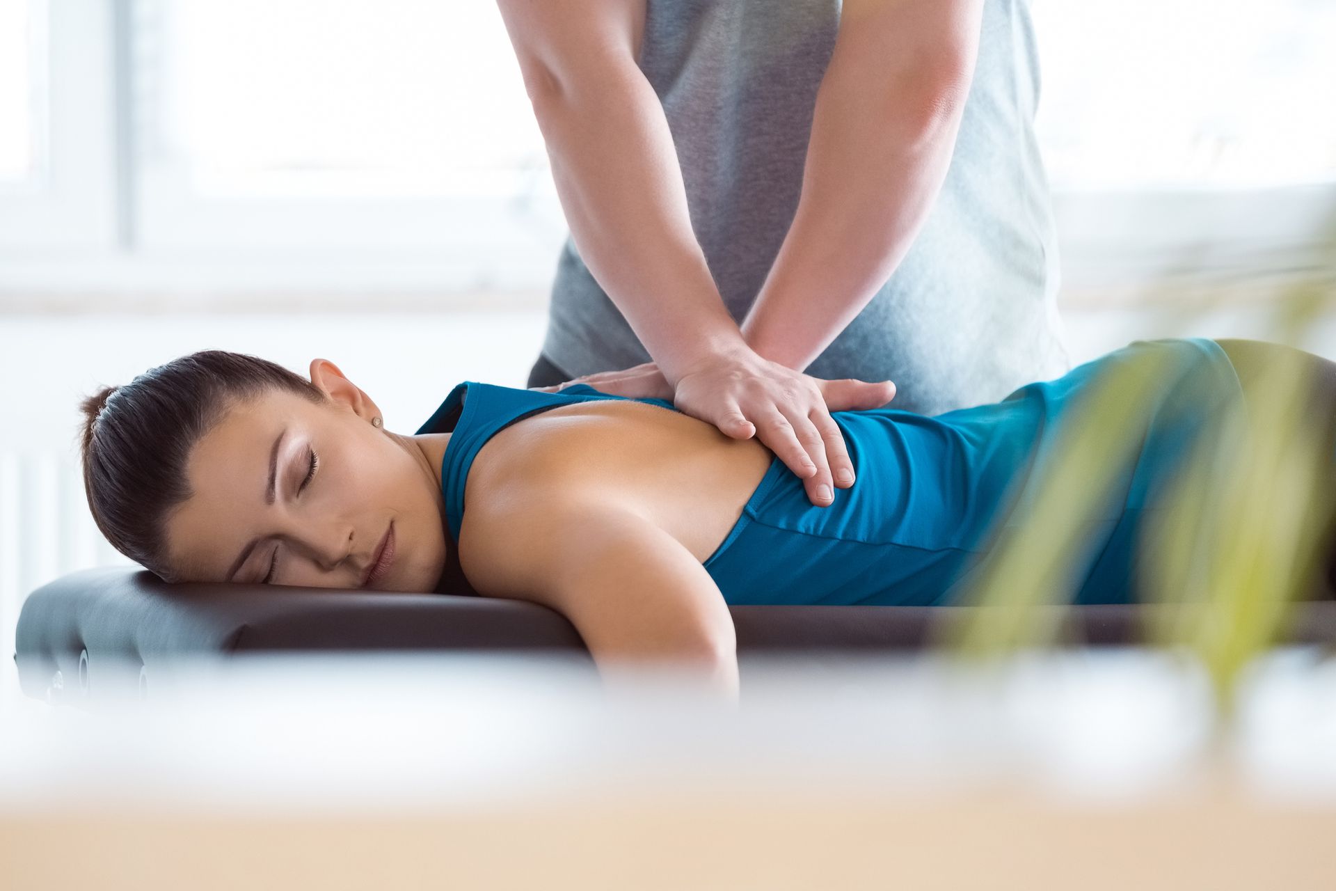 Massage therapist giving back massage to young woman | Advanced Physical Therapy | Philadelphia Pa 