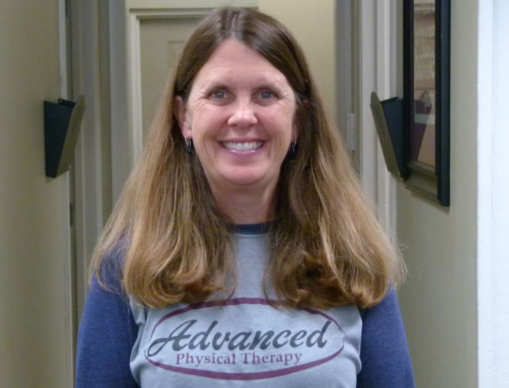 A smiling person in a blue and gray