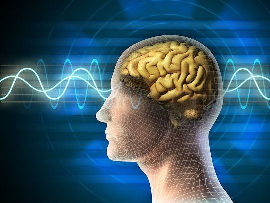 Human head silhouette with a golden brain and blue energy waves in the background.