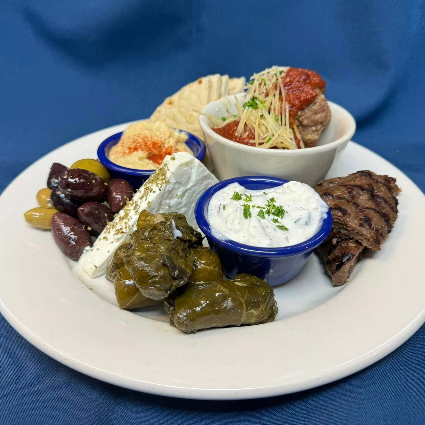 A white plate topped with a variety of food and sauces