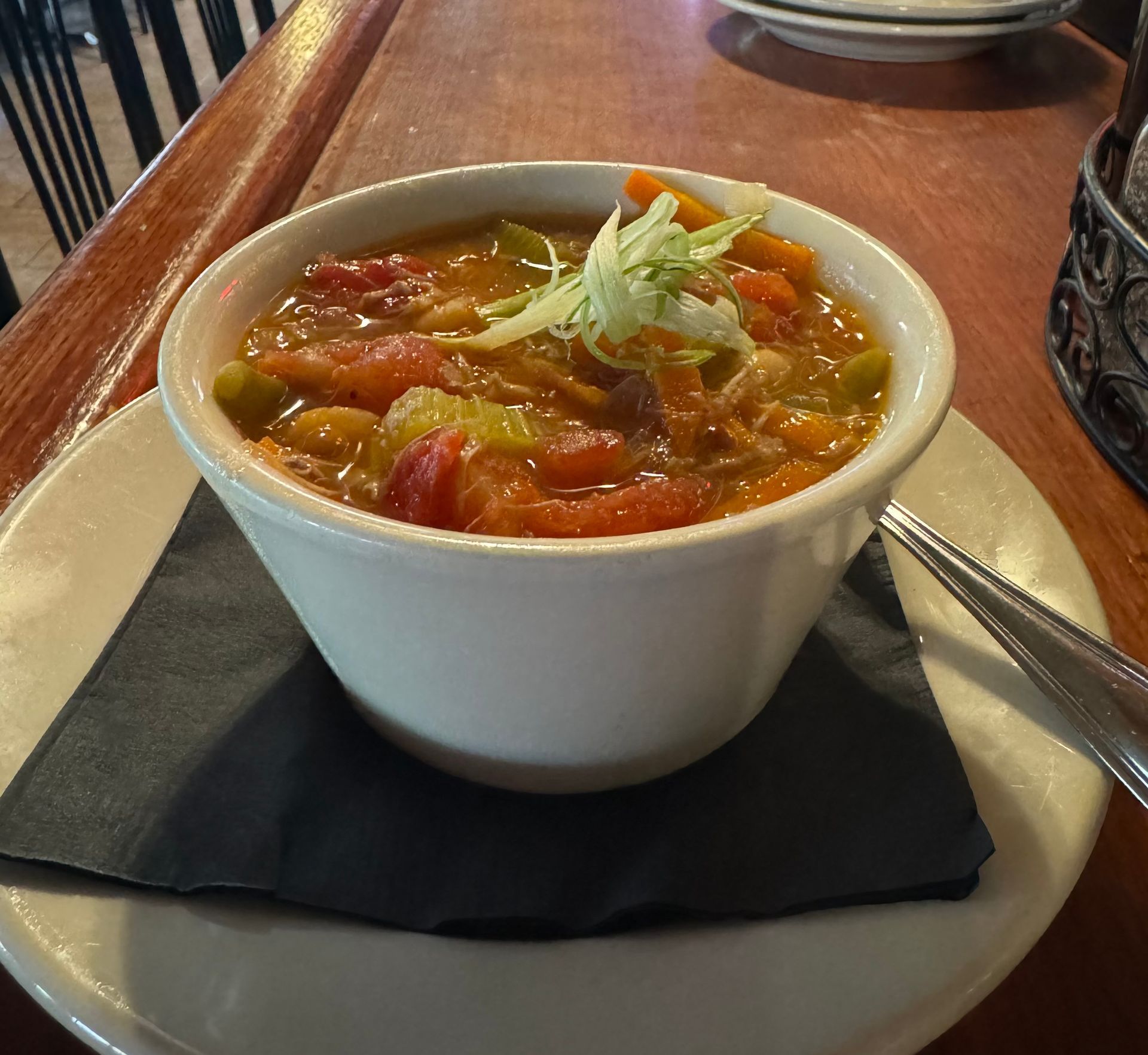 A bowl of Jake and Telly's soup on a plate with a spoon