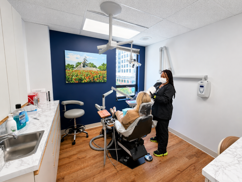 Dentist examining a patient in a bright, modern dental exam room