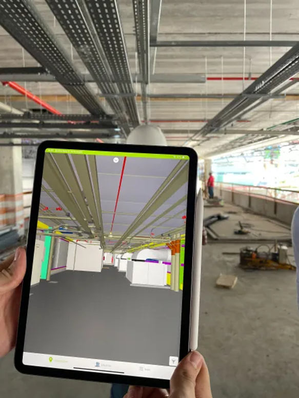 Uma pessoa está segurando um tablet com um modelo 3D de um edifício.