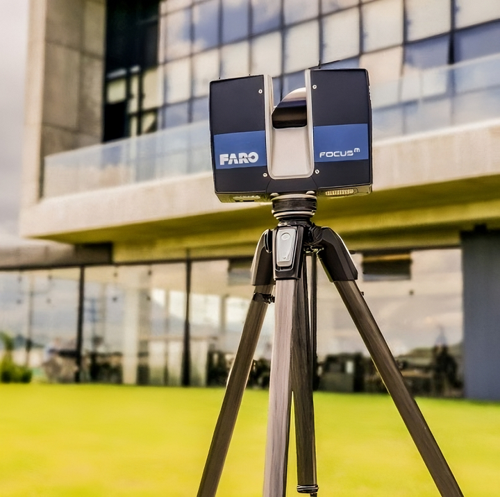 Uma câmera faro está em um tripé em frente a um prédio
