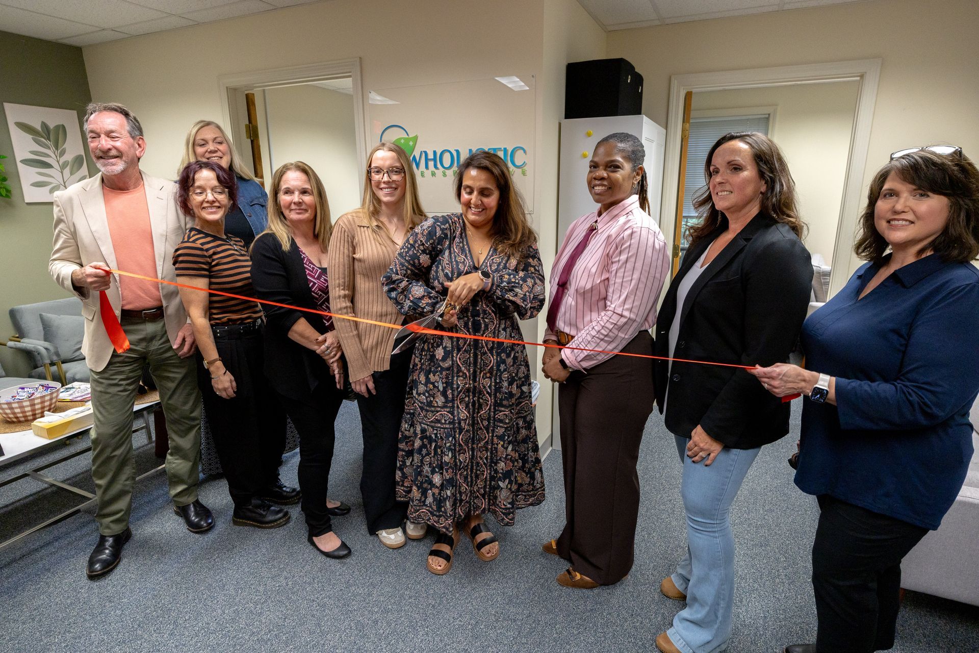 Esha and the Chamber of Commerce team cutting the ribbon for Wholistic Perpsective's grand opening