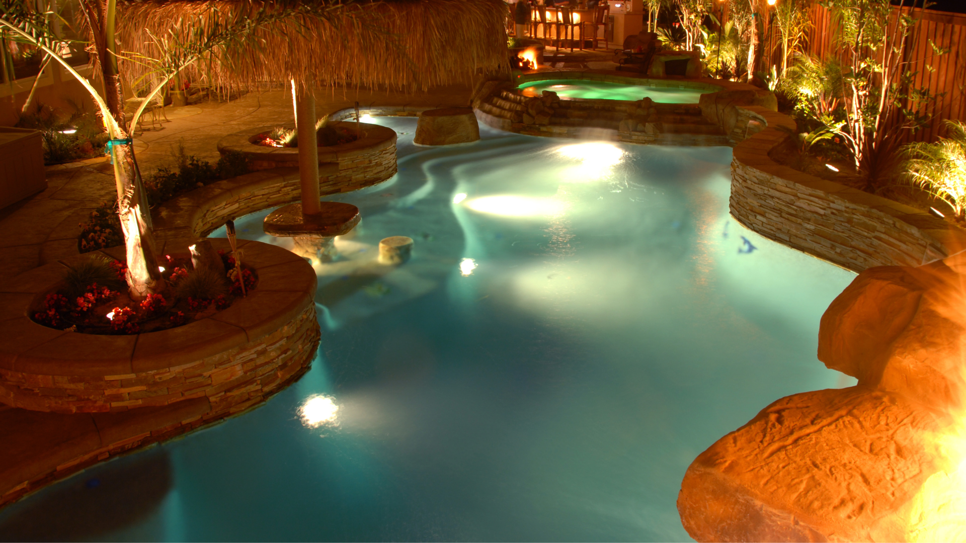 A hose , vacuum cleaner , and brush are sitting on the edge of a swimming pool.