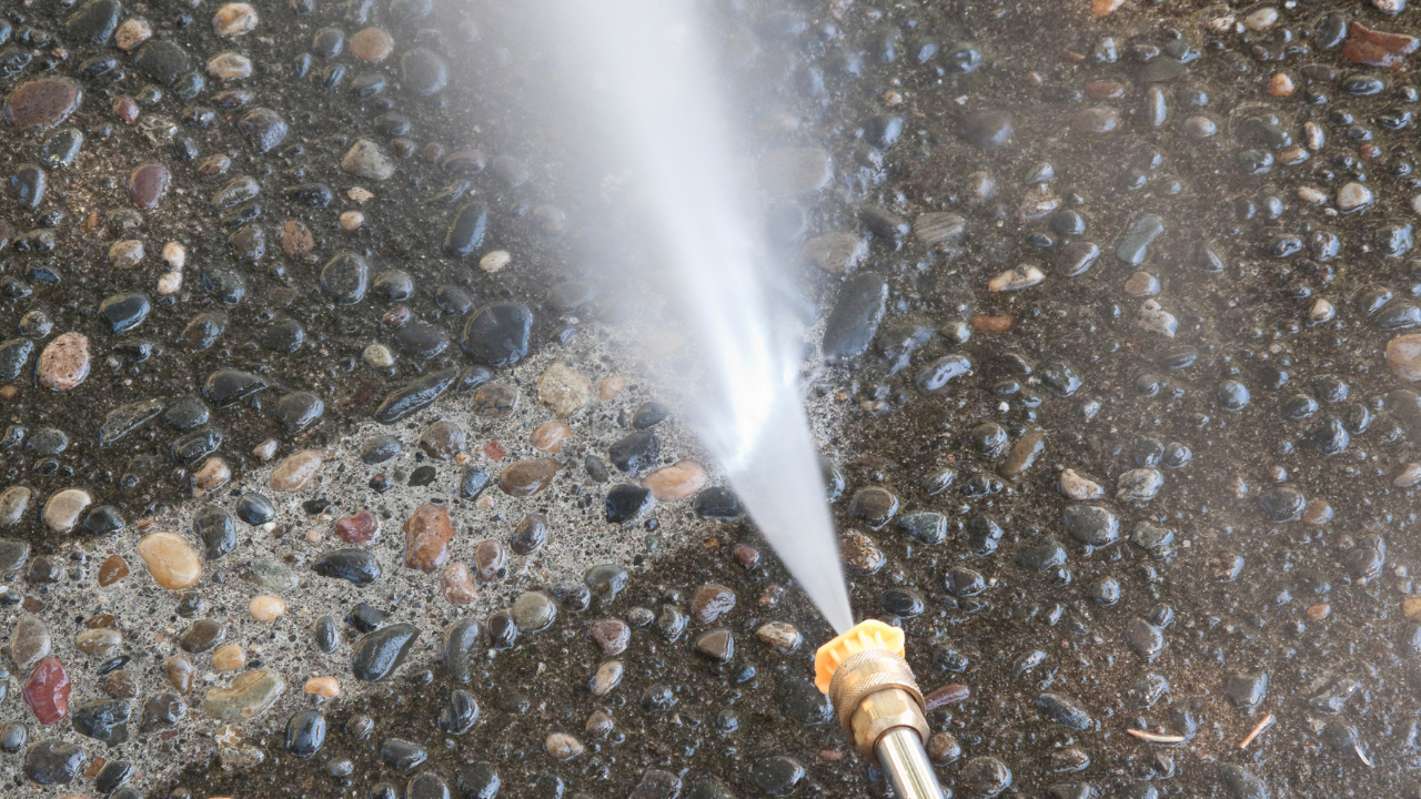 Pressure washer spraying water onto a stone surface.