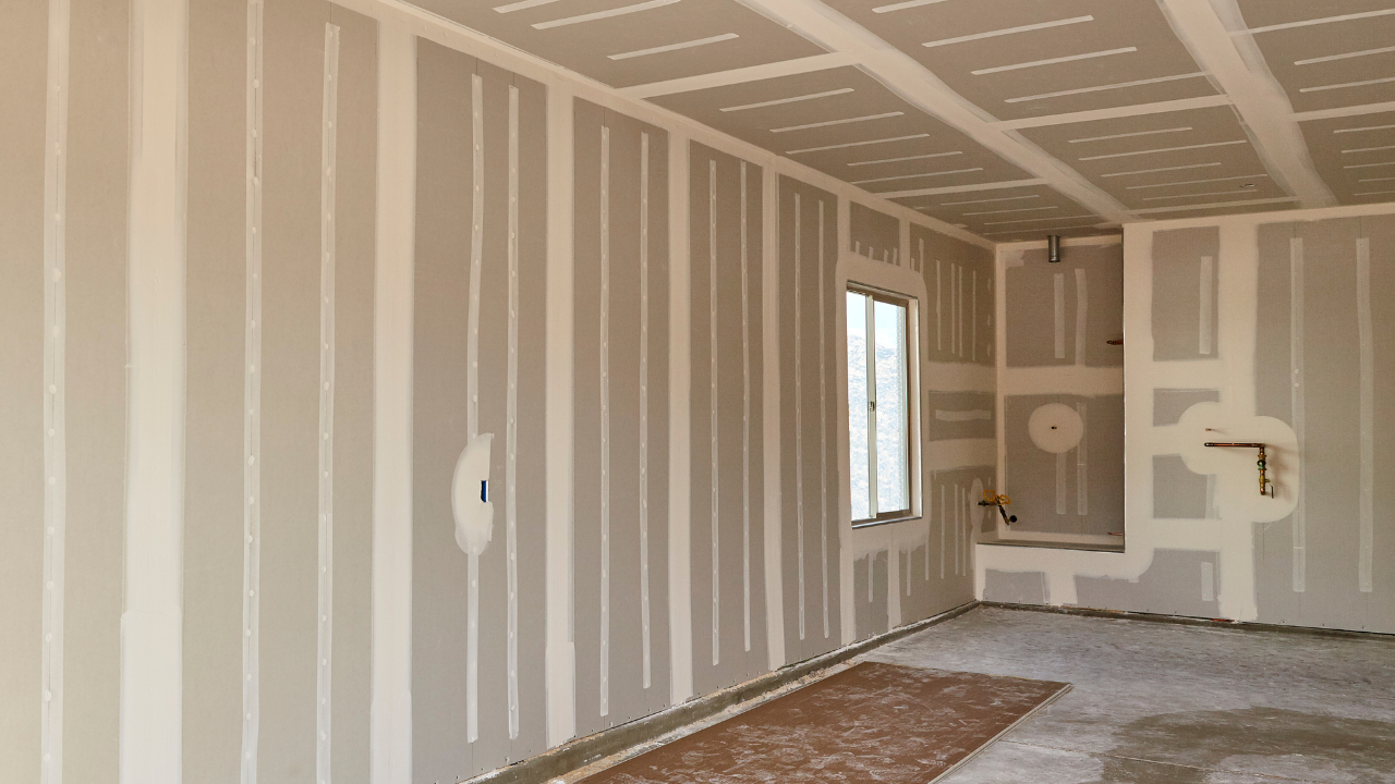 Interior room with drywall, taped seams, unfinished, showing a window and ceiling.
