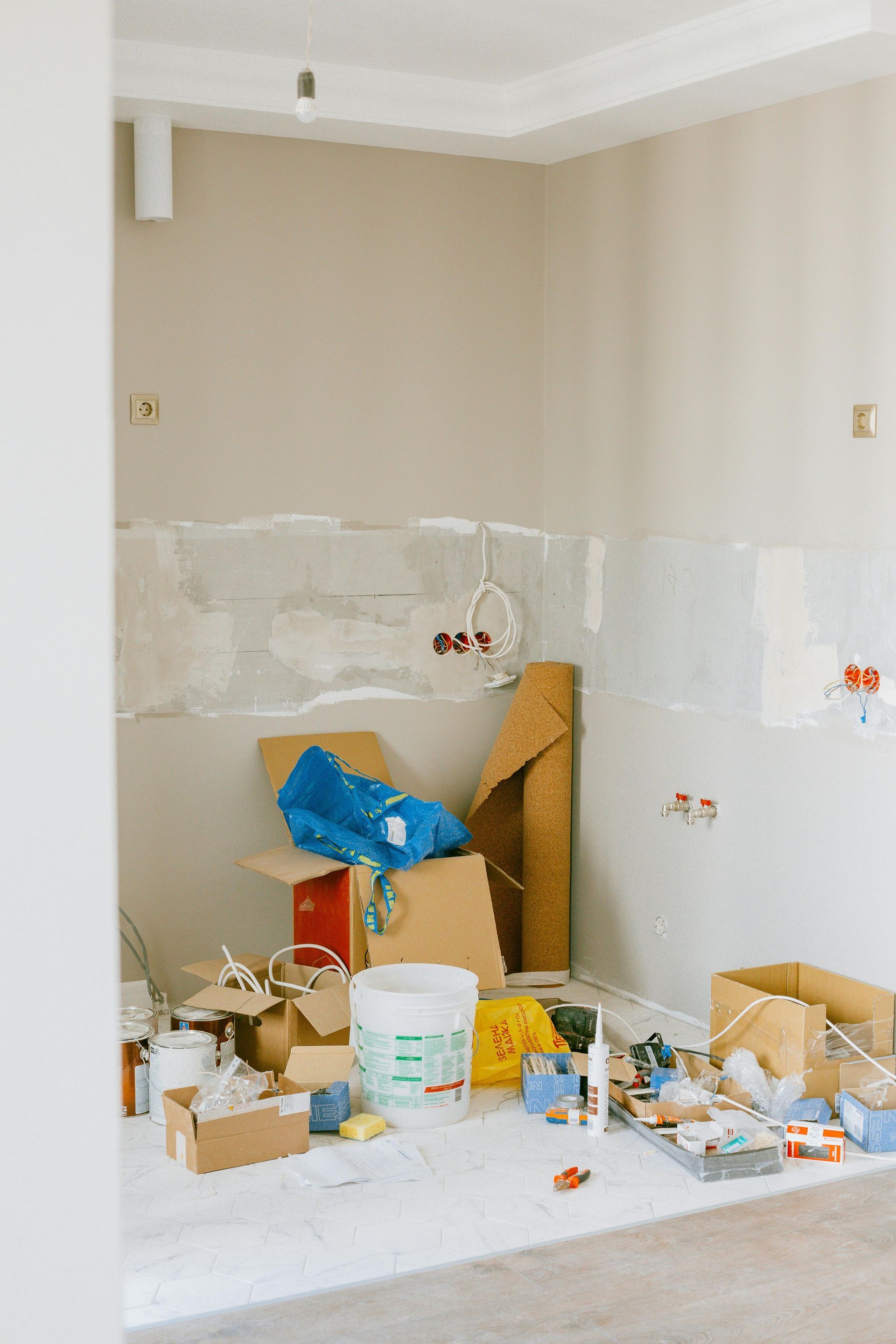 Room under construction with debris and exposed wiring on the walls.