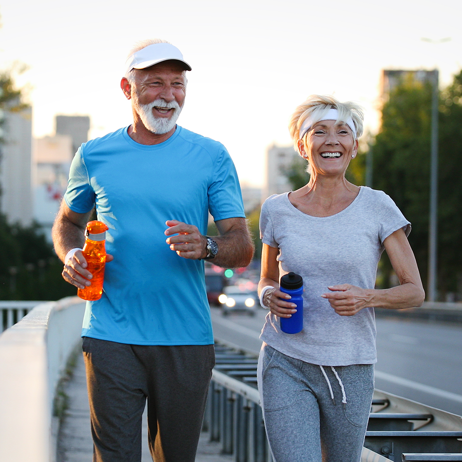 A man and a woman are jogging on a bridge.
