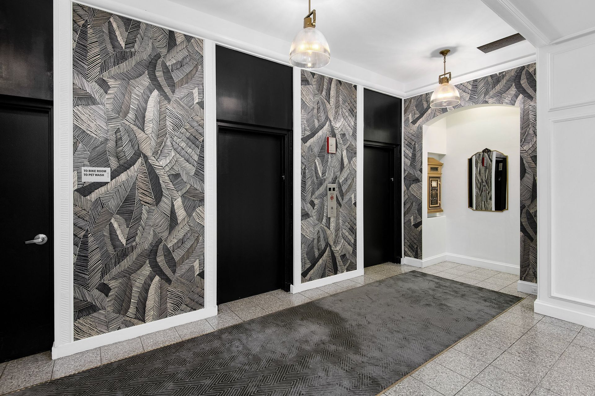 a hallway with black and white walls and carpet and doors