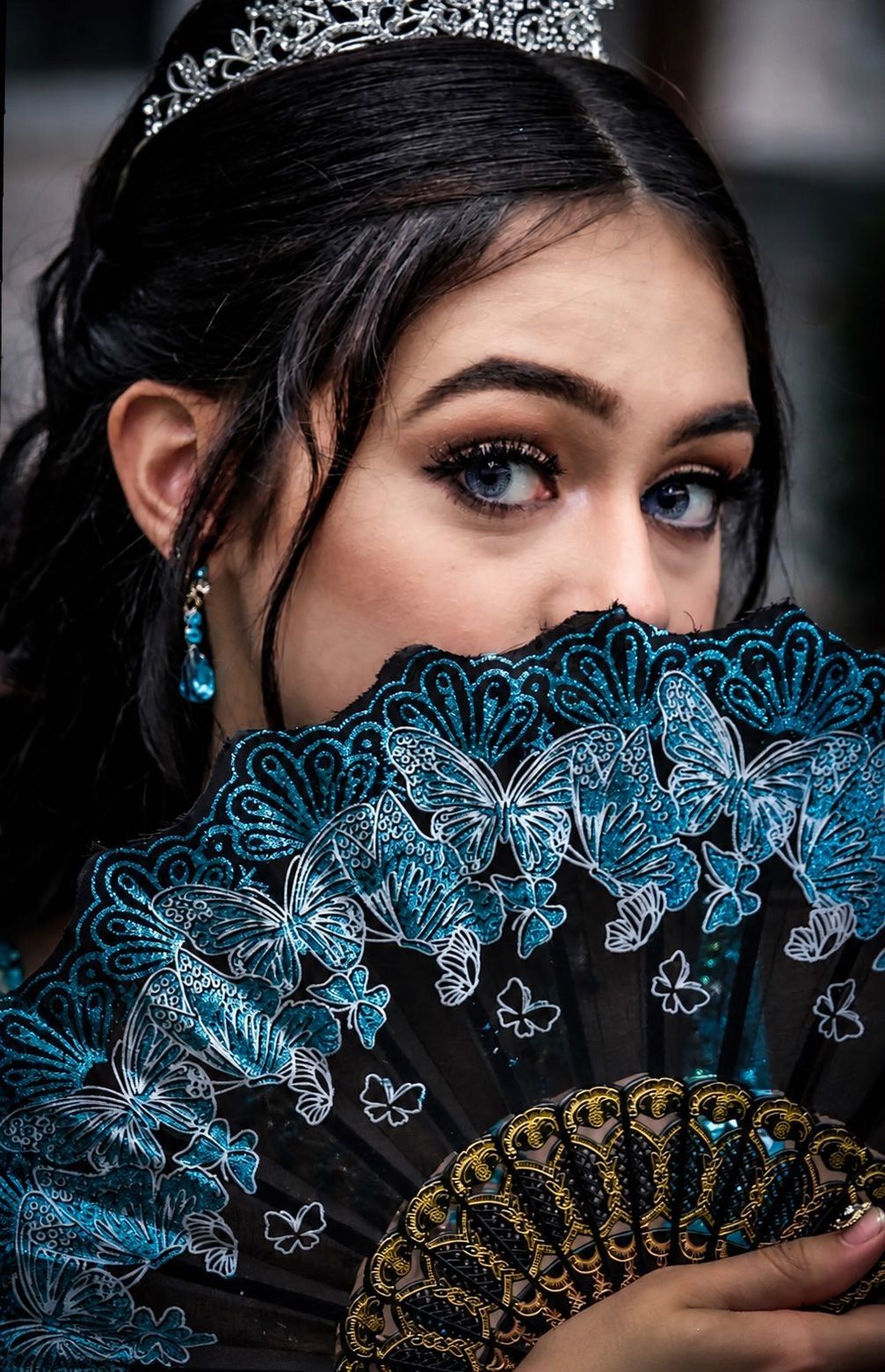 Cinematic edit of a young woman wearing a tiara and holding a decorative fan