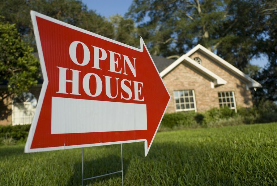 An Open House Sign in Front of a Brick House