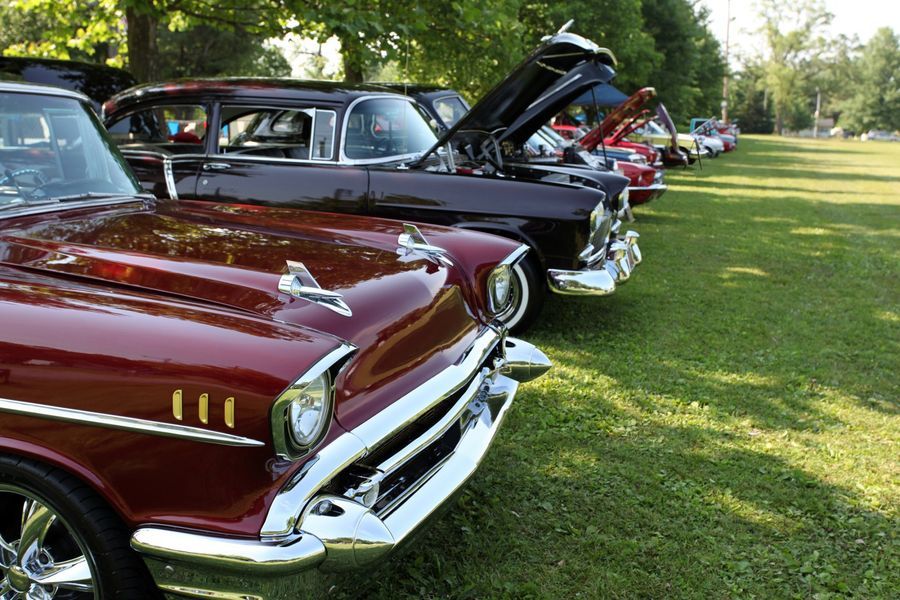 A Row of Old Cars Are Parked in a Grassy Field