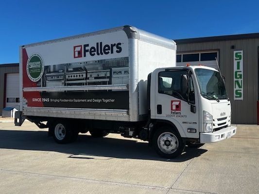 A fellers truck is parked in front of a building