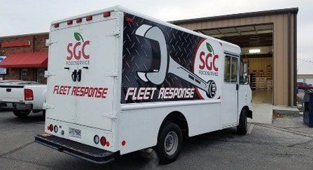 A fleet response truck is parked in front of a building