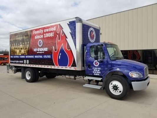 A blue truck is parked in front of a building