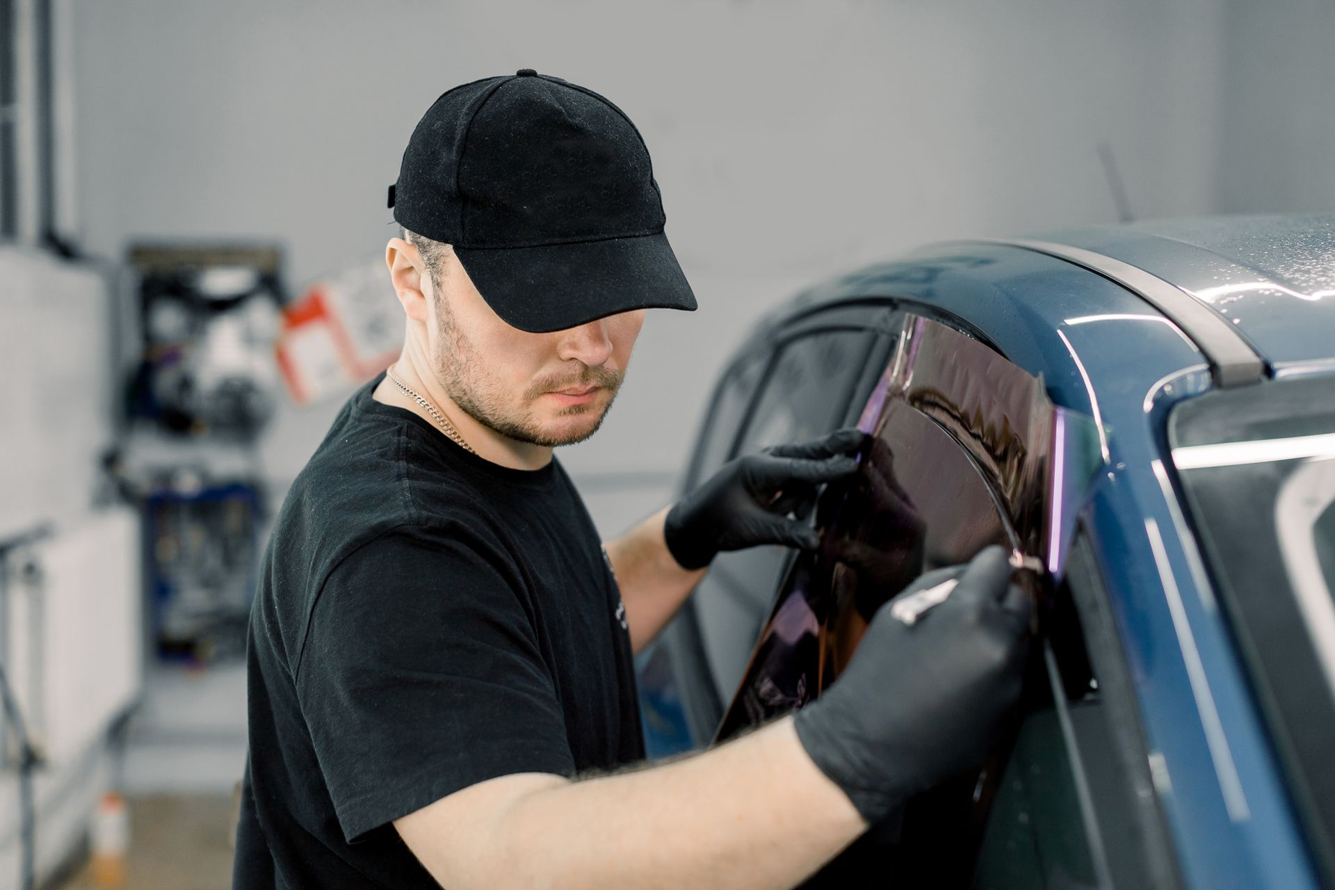 A Man is Applying Tinted Glass to a Car Window