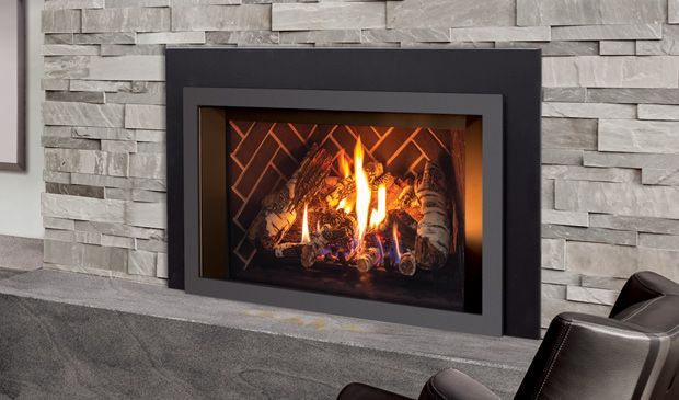 Modern fireplace with flames, set in a stone wall and dark gray frame.