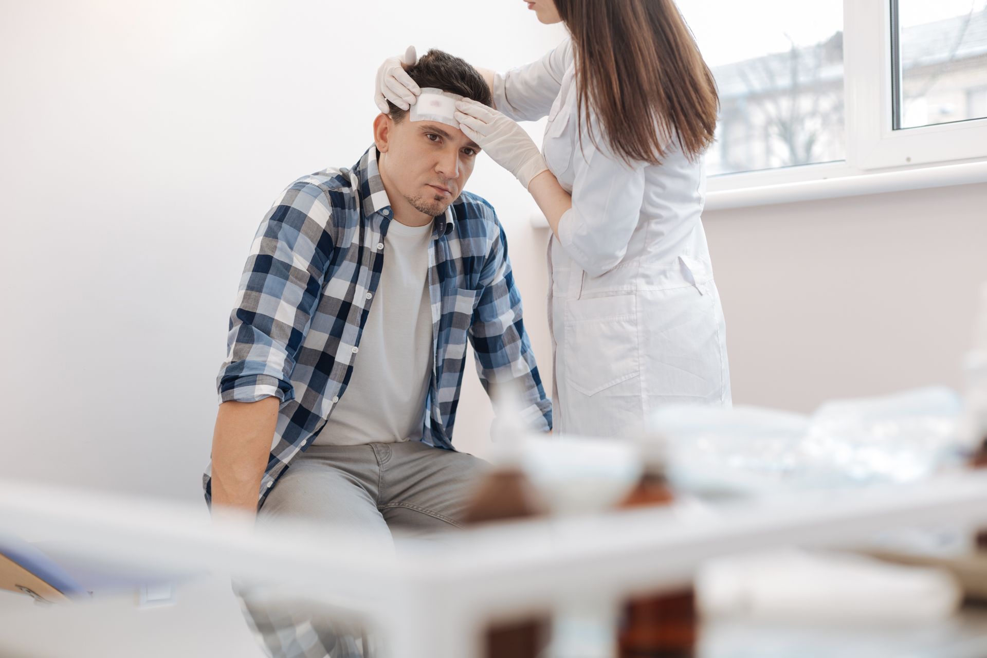 Person checking another person’s forehead with a thermometer in a bright room