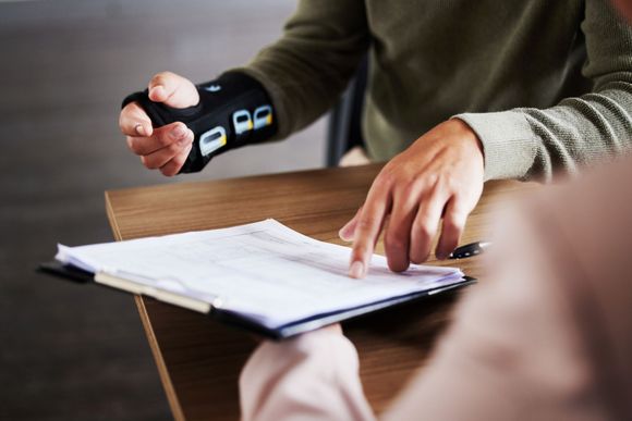 Person using a stamp to sign documents on a desk during a meeting