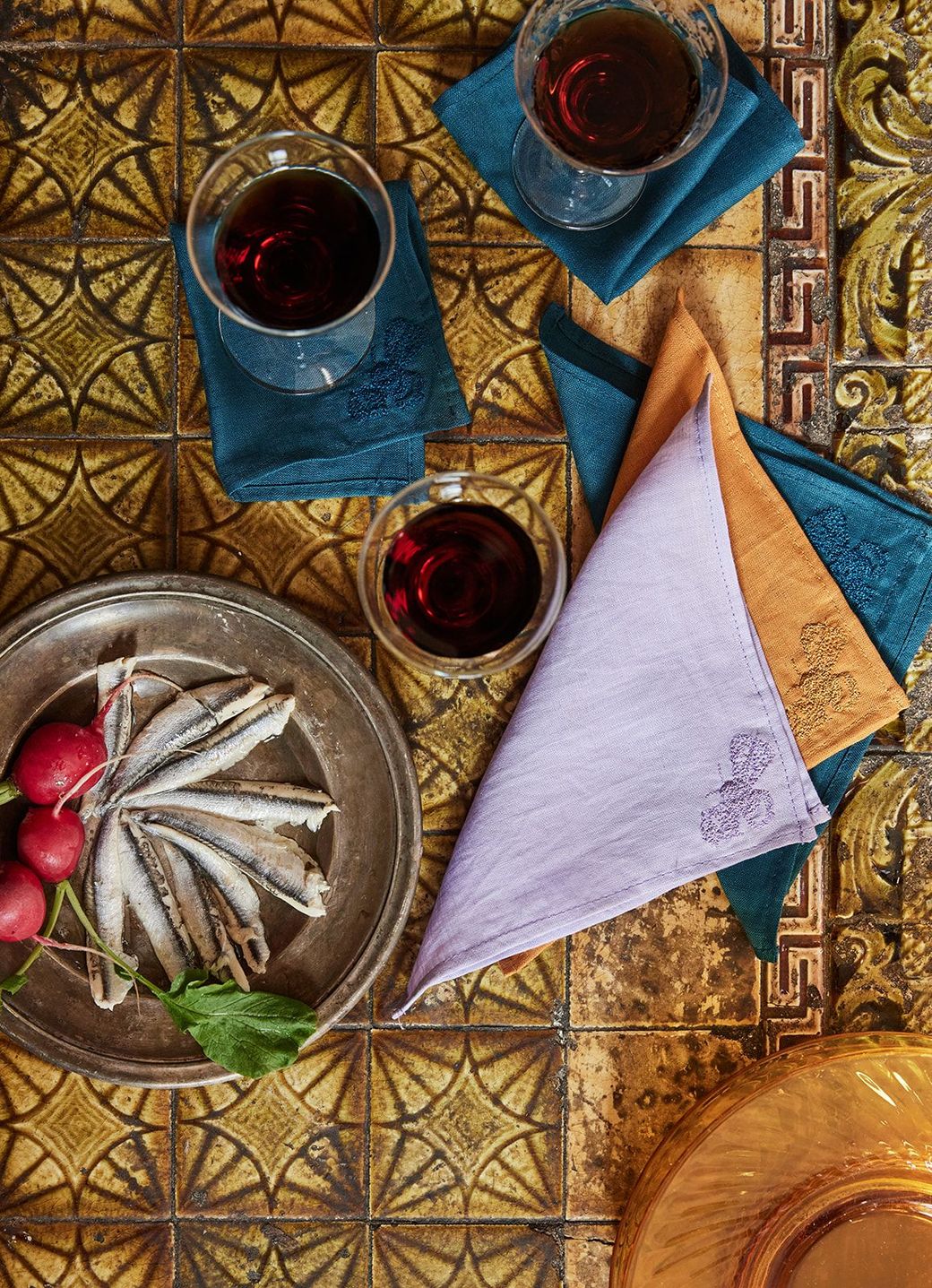 A table with a plate of food and glasses of wine on it.
