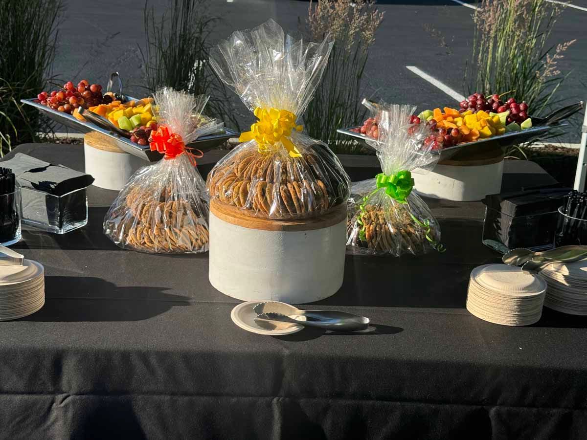 A table with a bunch of food on it and plates on it.