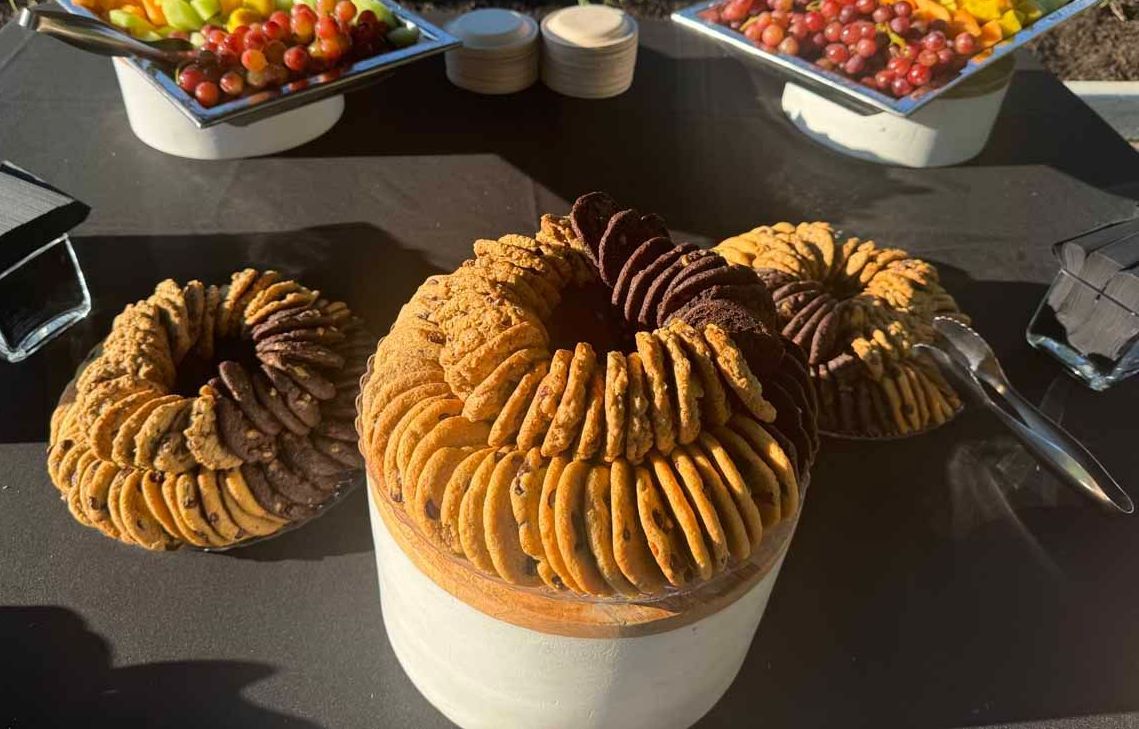 Three bundt cakes are sitting on top of a white plate on a table.