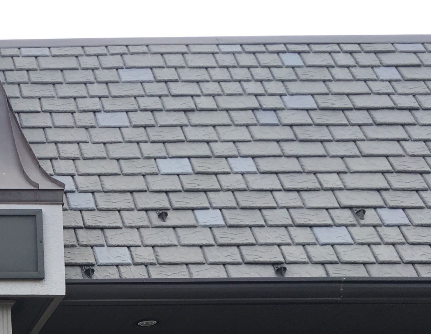 Mansard-style synthetic slate roof with installed snow guards for enhanced winter safety Mansard-style synthetic slate roof with installed snow guards for enhanced winter safety