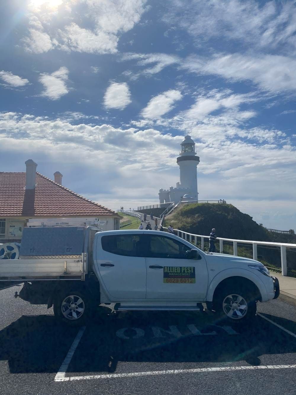 A White Truck Is Parked in A Parking Lot in Front of A Lighthouse — Allied Pest Management Northern Rivers in Byron Bay, NSW