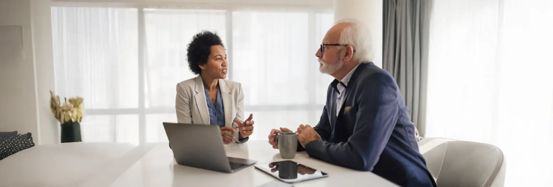 Um homem e uma mulher estão sentados à mesa conversando um com o outro.