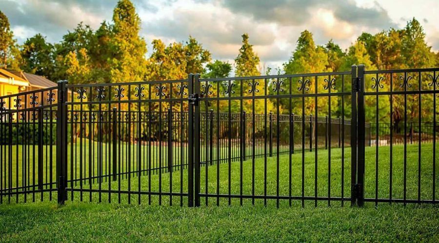 Black ornamental aluminum fence and gate in a residential backyard.