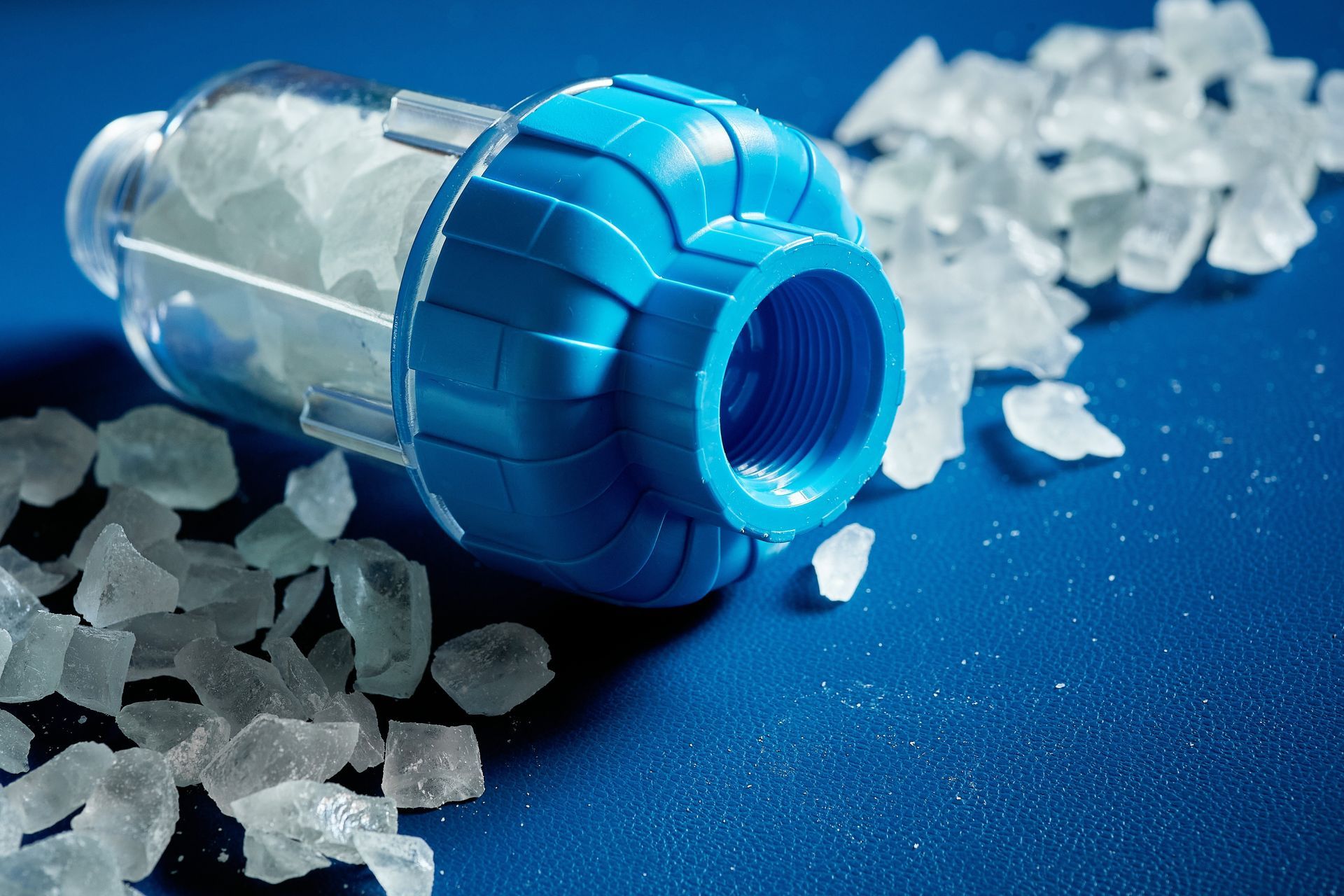 water filter with a crumb of salt crystals on a blue background.