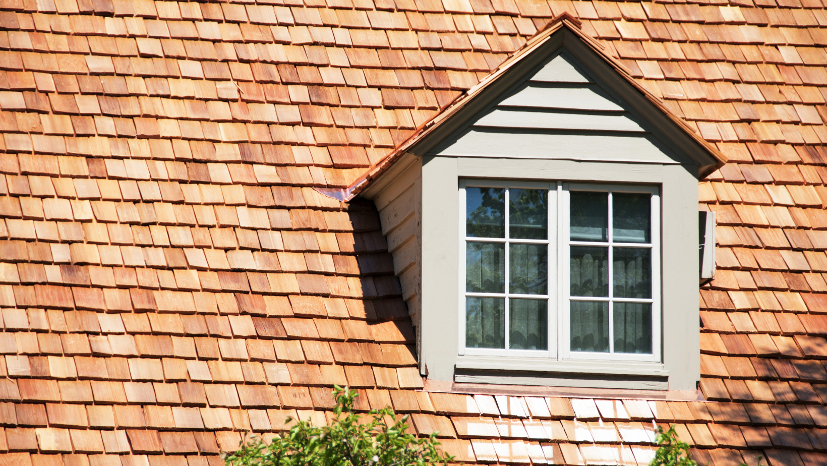 A window on the side of a house with a wooden roof