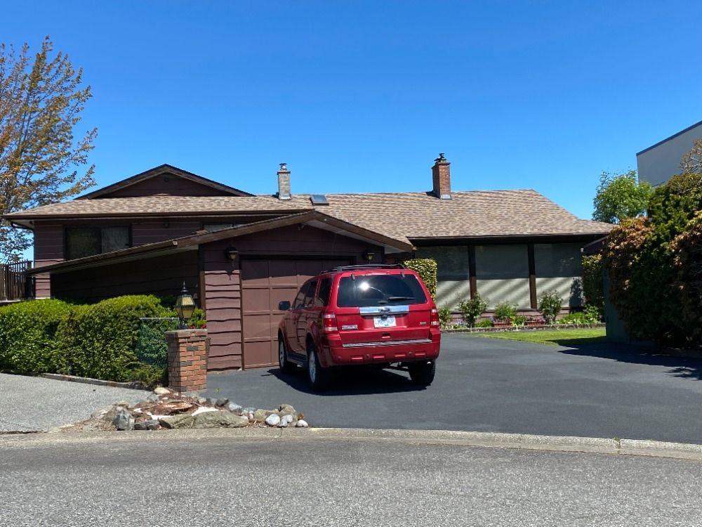 A red car is parked in front of a house