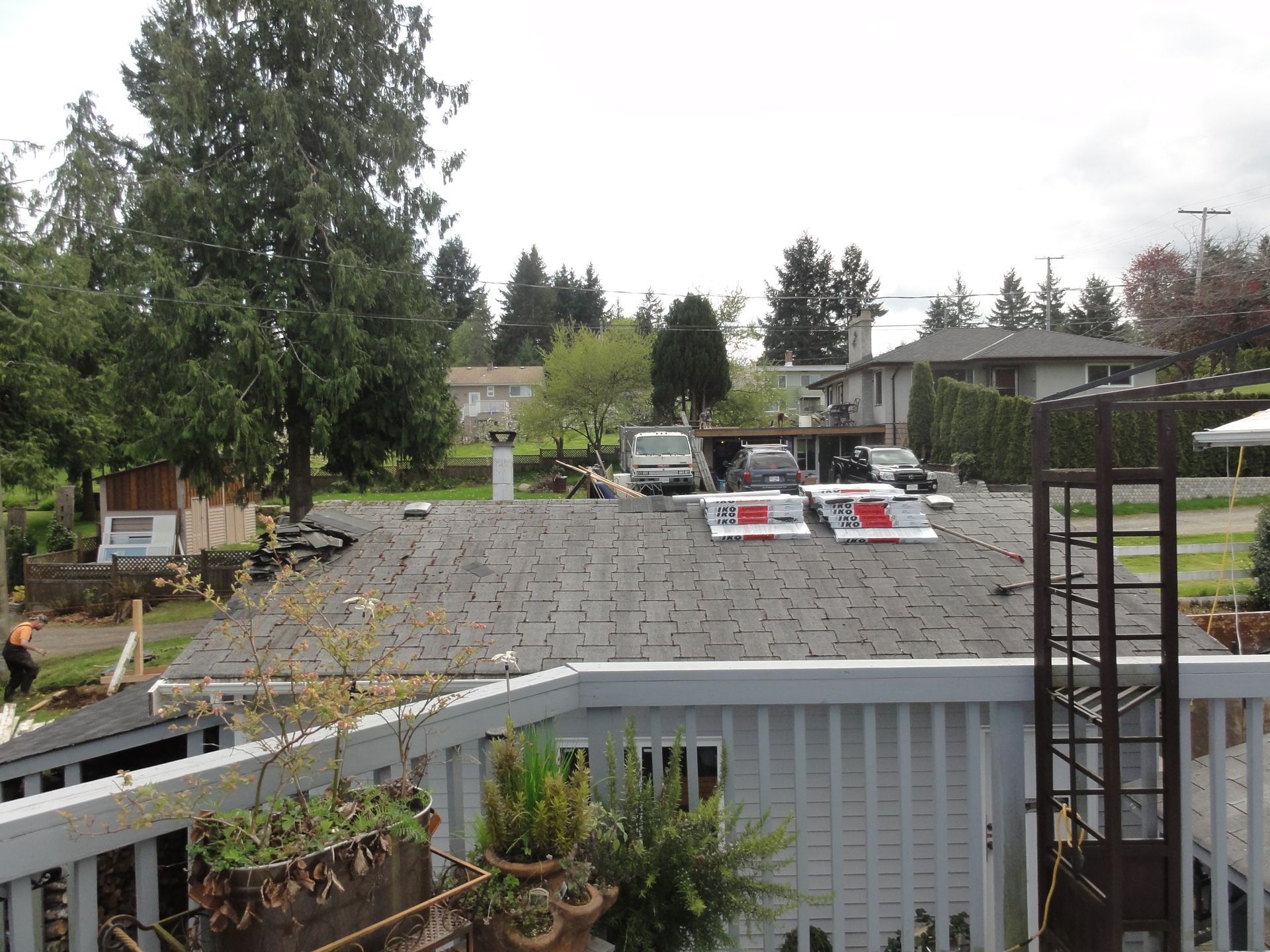 A view of a roof from a balcony with trees in the background