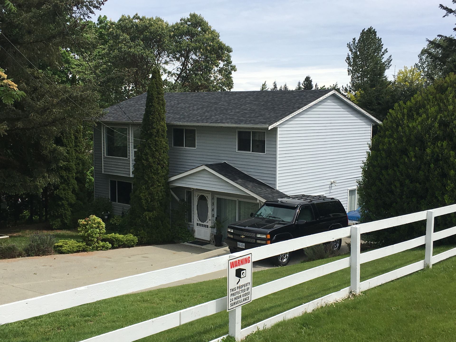 A large white house with a black suv parked in front of it