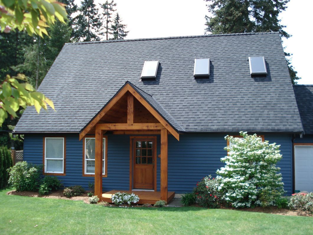 A blue house with three skylights on the roof