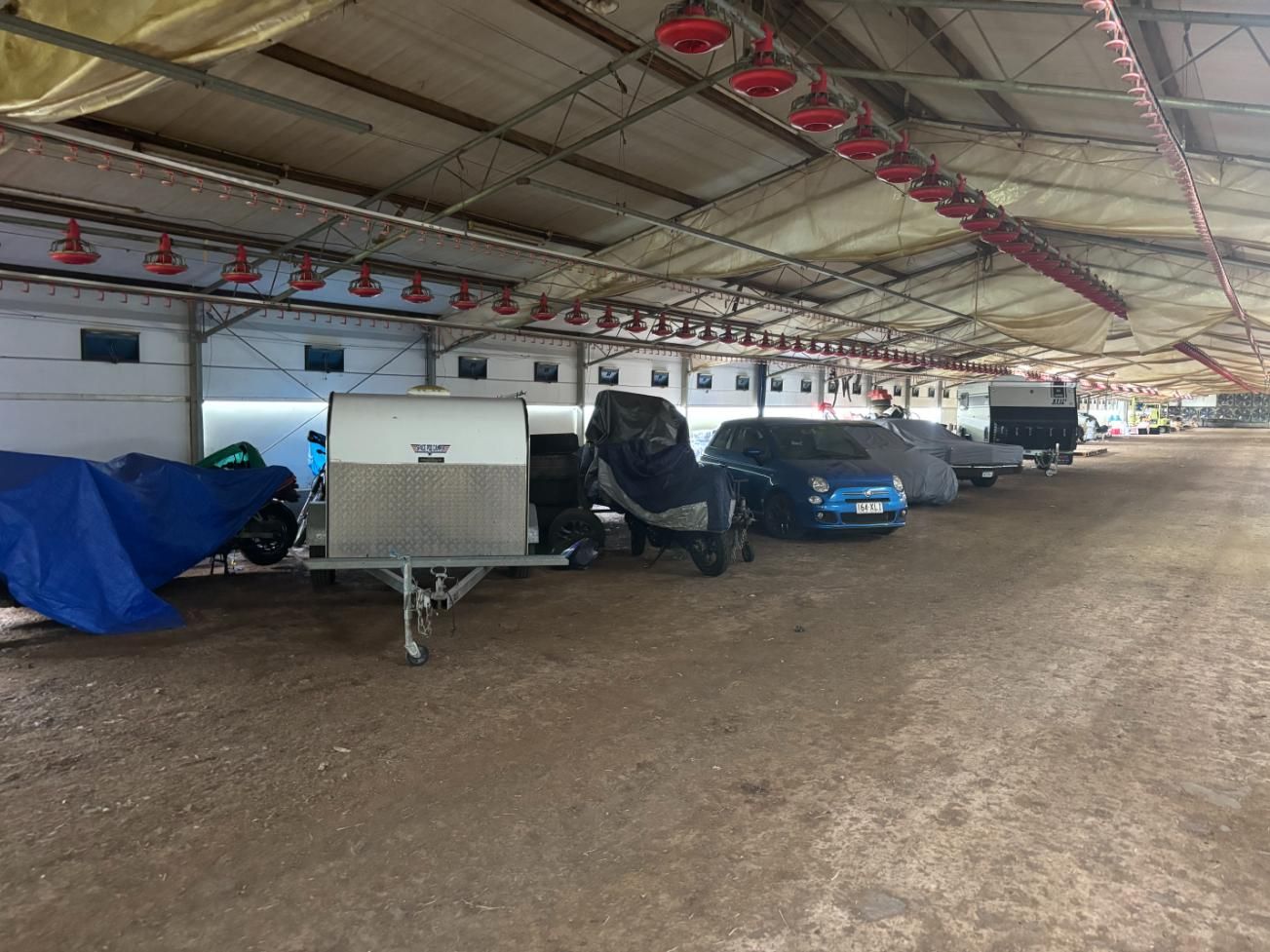 A Row Of Cars And Trailers Are Parked Inside Of A Building — Byron Storage Services In Myocum, NSW