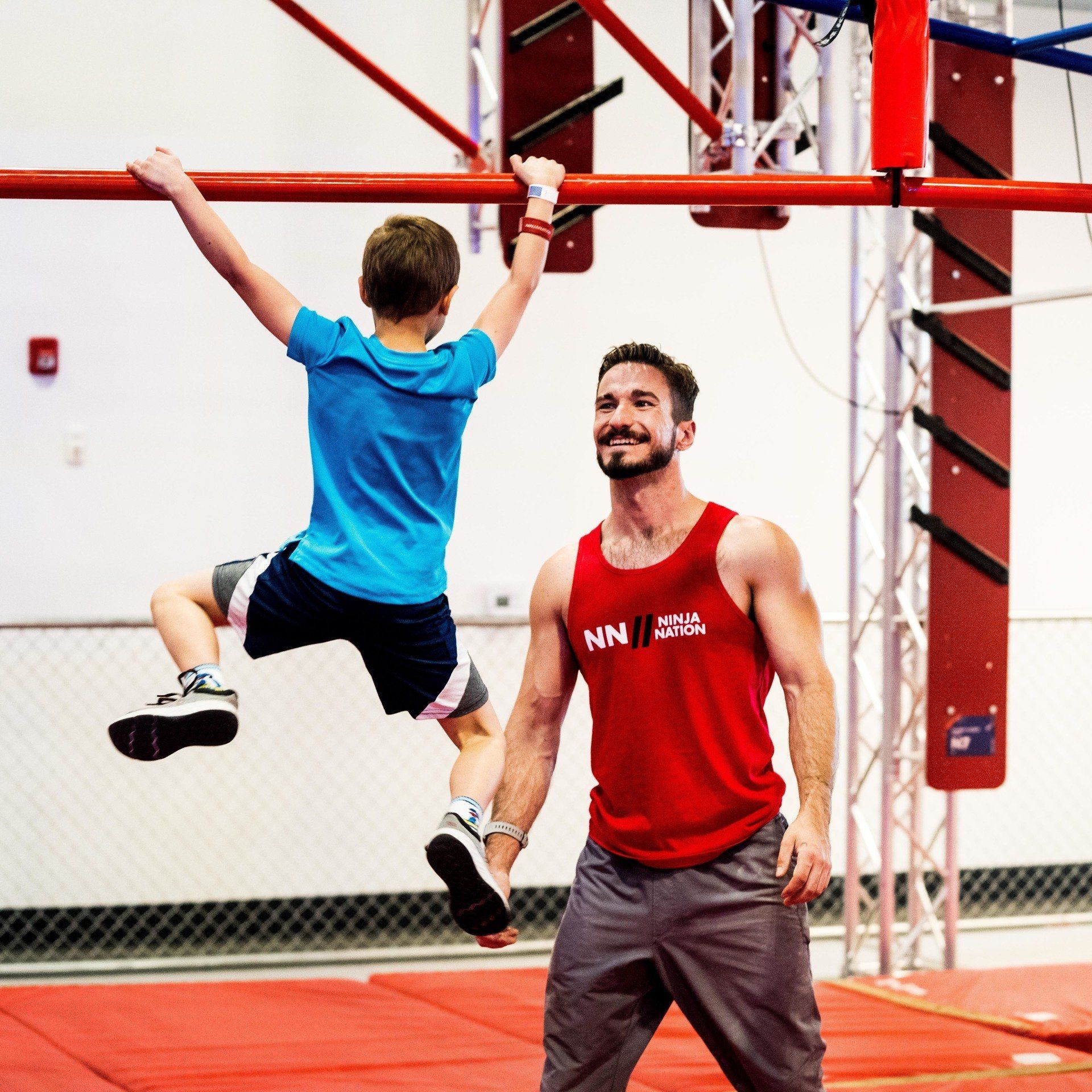 instructor helping a kid learn new obstacles at Ninja Nation
