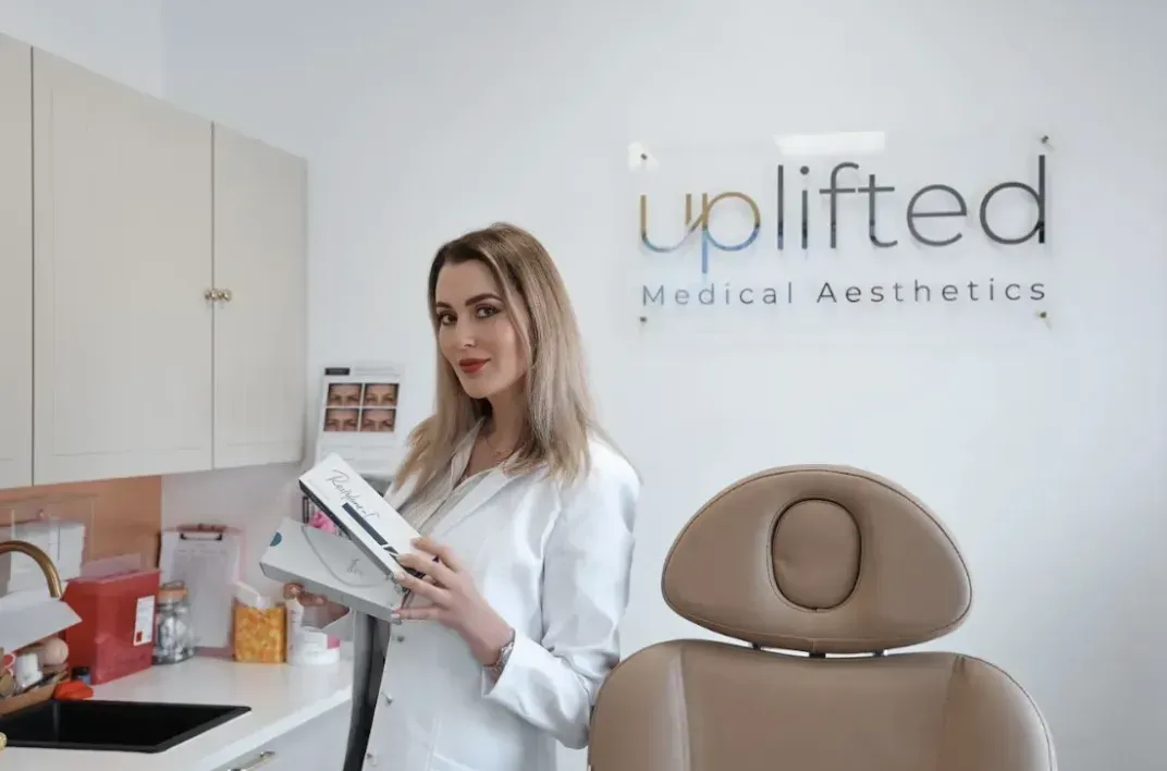 Hula Castellon, FNP, MSN, and owner of Uplifted Aesthetics , holding skincare product. 