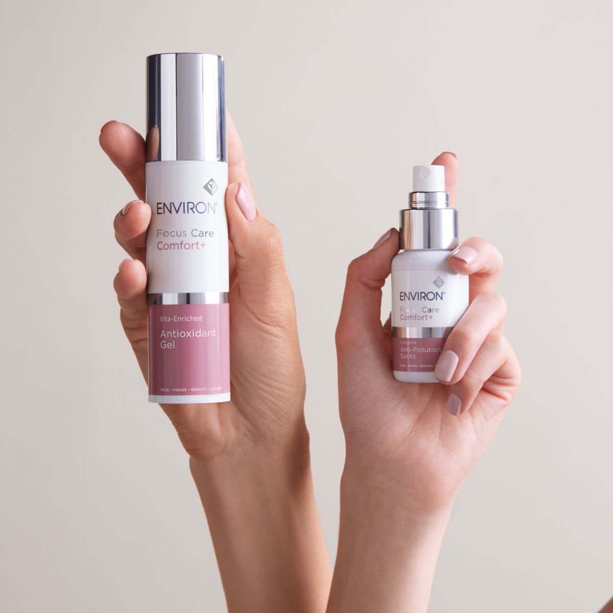 Two skincare product bottles held in hands against a neutral backdrop.