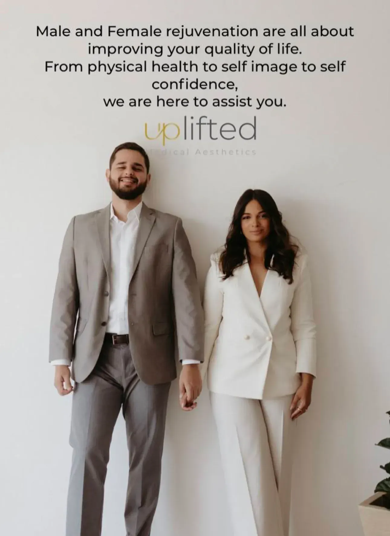 A man and woman stand in front of a white wall. Text above reads 