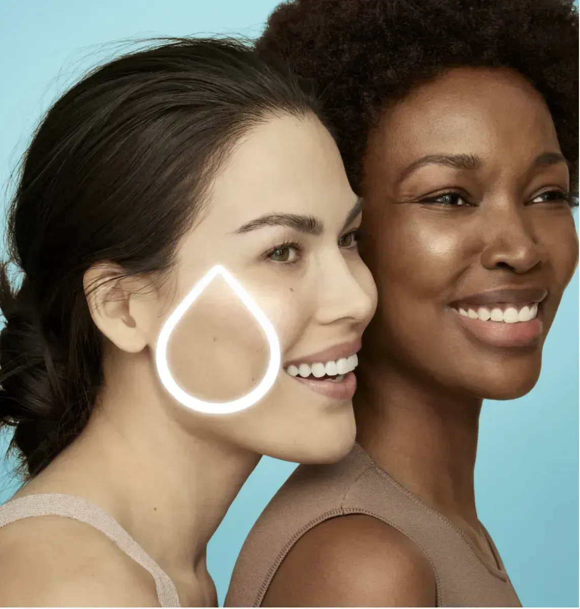Two smiling women, one with a highlighted teardrop shape on her cheek, against a light blue background.
