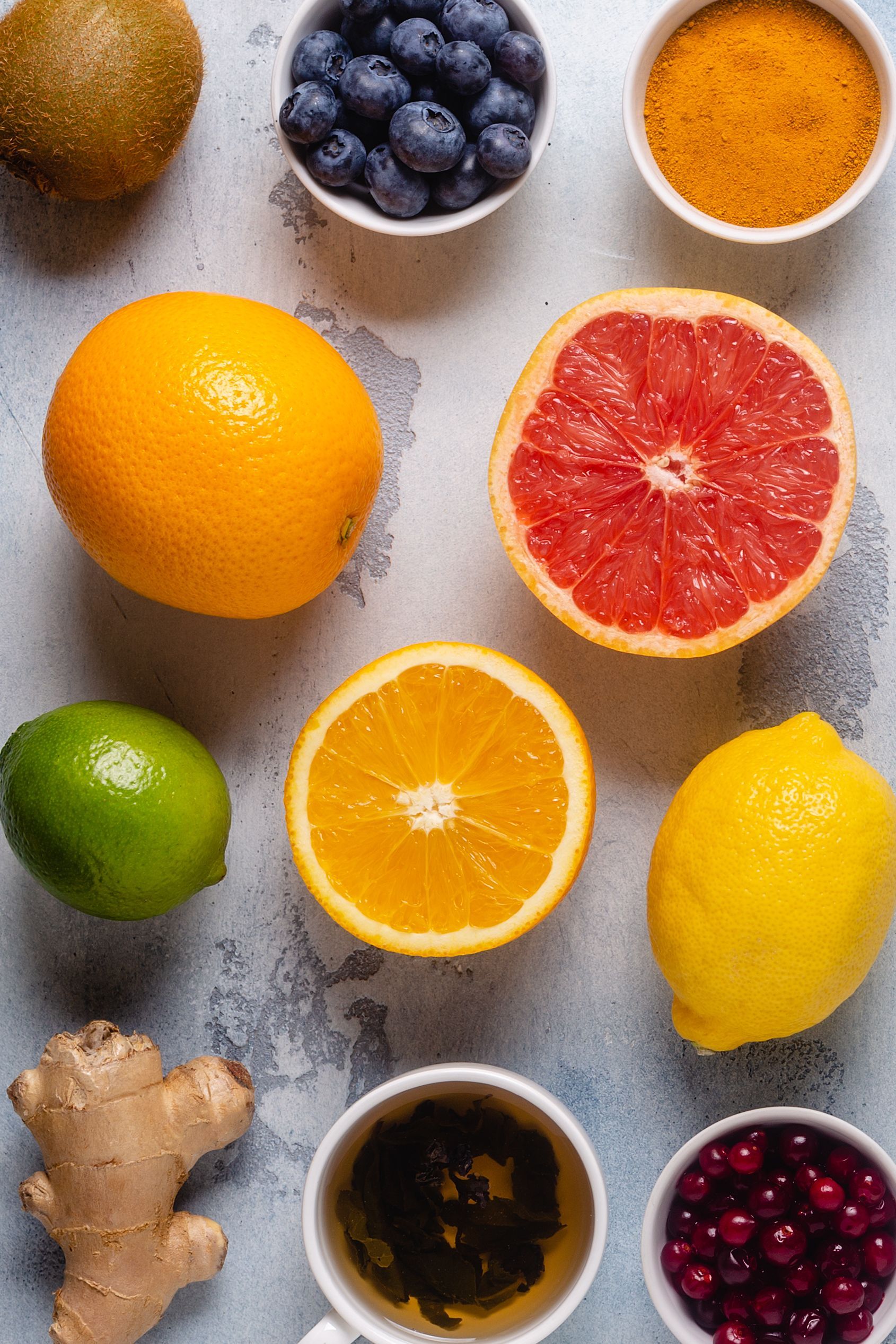 Assortment of fruits and spices for health: kiwi, blueberries, turmeric, orange, and grapefruit