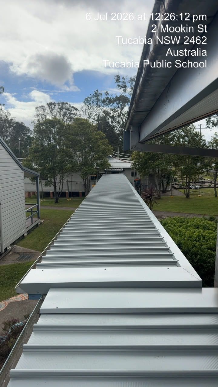 Long white sloped ramp between school buildings under a cloudy sky