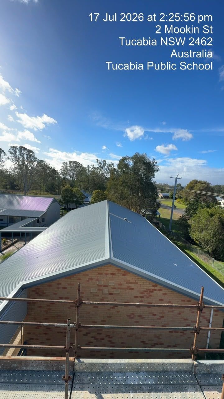 Rooftop view of a school building, trees, and blue sky at Tucabia Public School, Australia