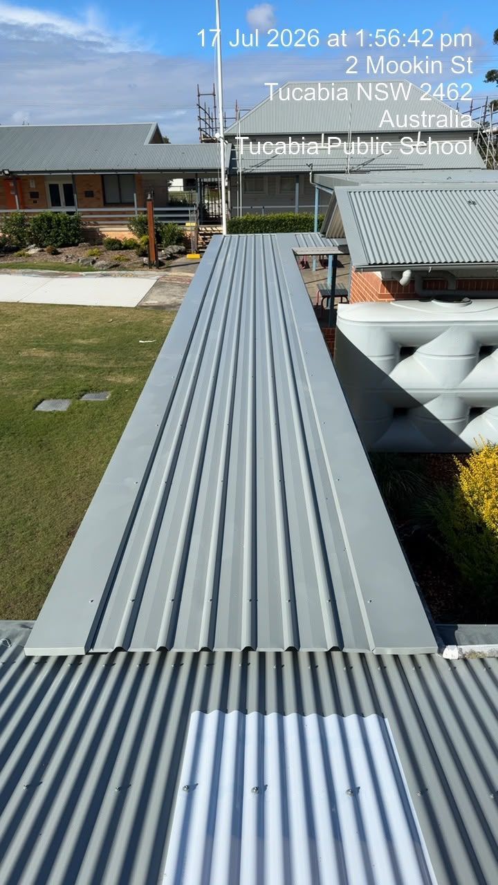 Long gray metal ramp leading to a house patio under a blue sky